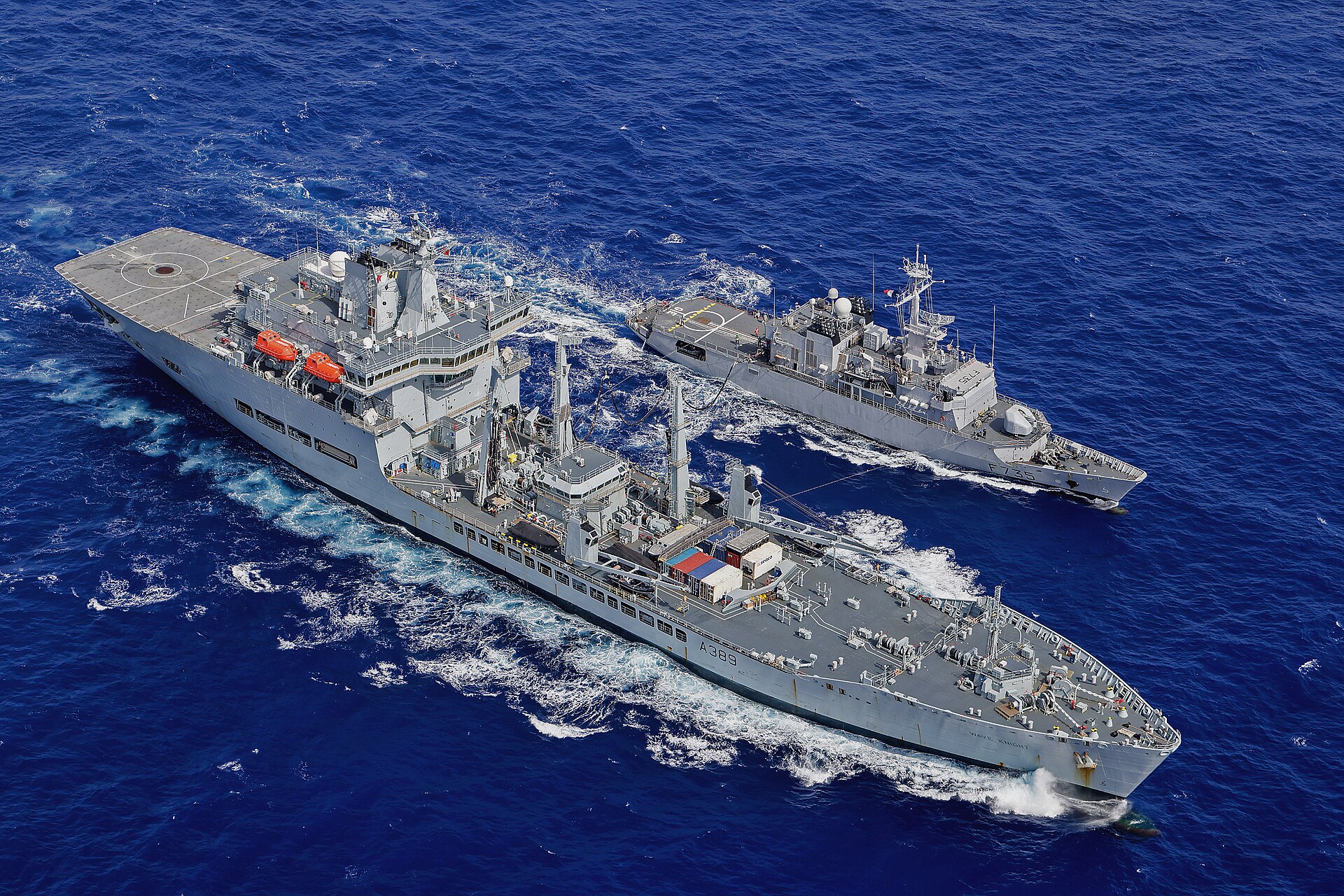 A naval supply ship replenishing a frigate at sea