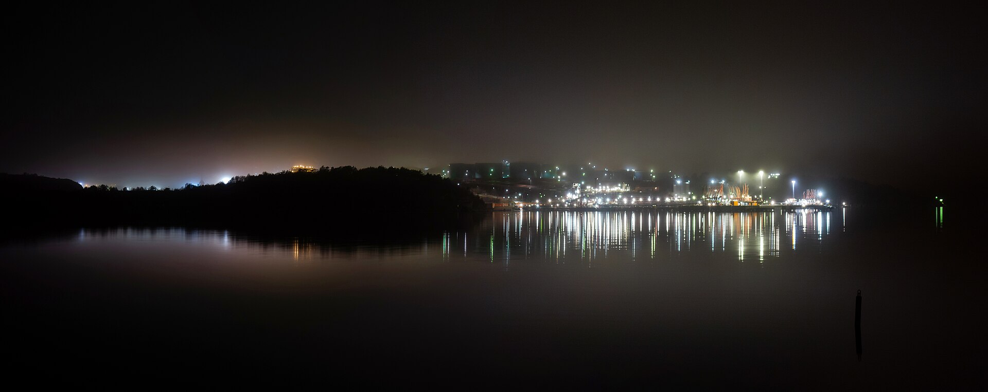 An oil refinery lit up on a foggy night